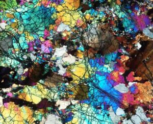 A thin slice of the ancient rocks collected from Gakkel Ridge near the North Pole, photographed under a microscope and seen under cross-polarized light. Field width ~ 14mm.Credit: E. Cottrell, Smithsonian.